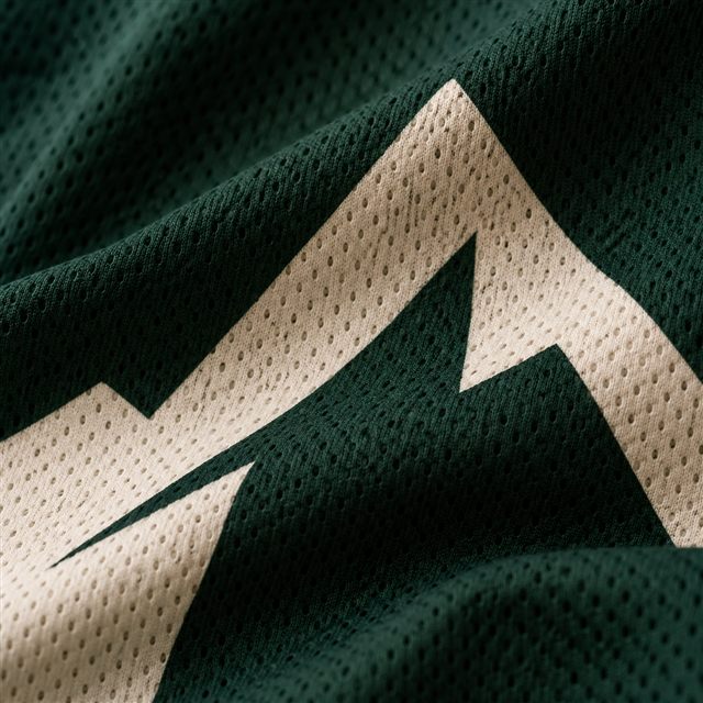 Sublimated ivory mountain crest following the weave of forest green jersey mesh